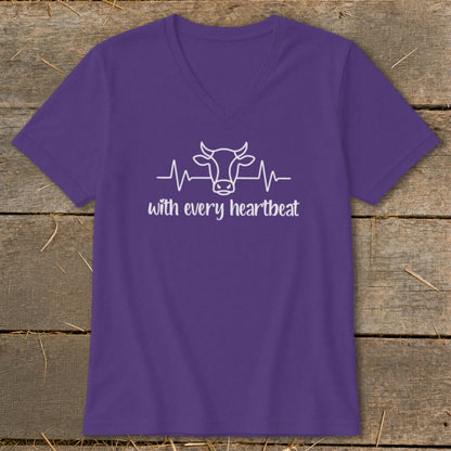 Purple v-neck t-shirt with white outline of a cow head and heartbeat line, text "with every heartbeat".