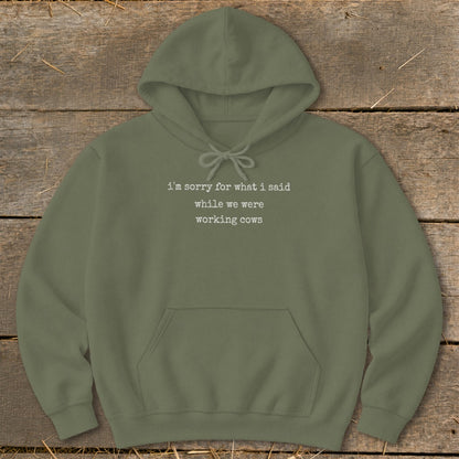 Olive green hoodie with white text: "i'm sorry for what i said while we were working cows"