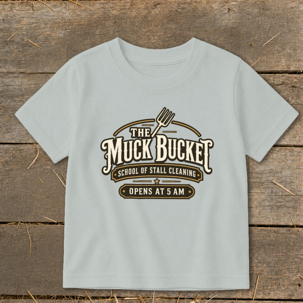 Light blue t-shirt with "The Muck Bucket School of Stall Cleaning Opens at 5 AM" graphic.