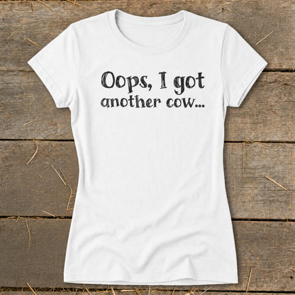 White t-shirt with black text that reads "Oops, I got another cow...".