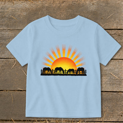 T-shirt with four horses grazing in front of a stylized sunrise graphic.
