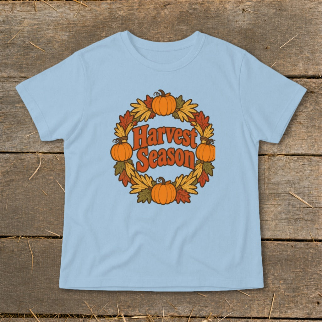 Light blue t-shirt with "Harvest Season" text inside a pumpkin and leaf wreath.