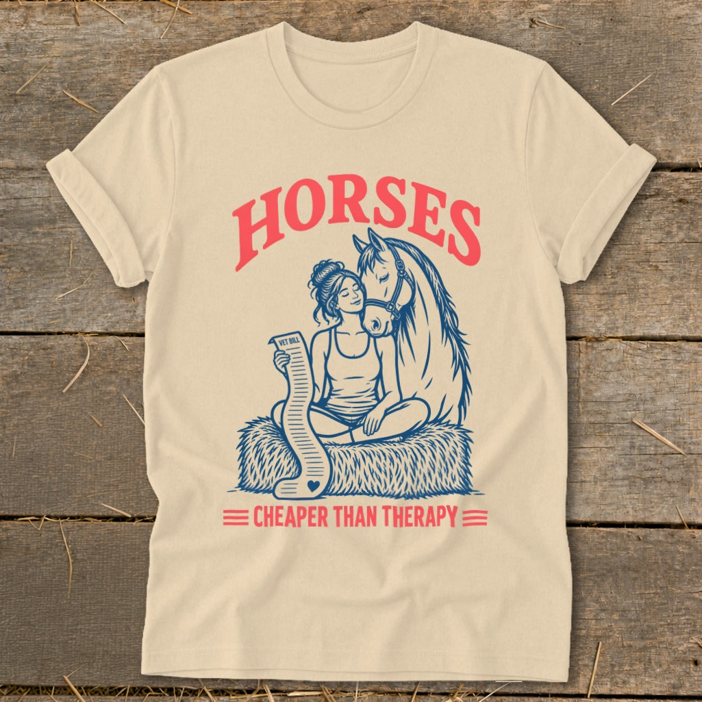 Cream t-shirt with illustration of woman holding vet bill next to a horse, text "HORSES CHEAPER THAN THERAPY".
