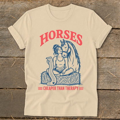 Cream t-shirt with illustration of woman holding vet bill next to a horse, text "HORSES CHEAPER THAN THERAPY".