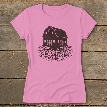 Pink t-shirt with a dark brown barn on deep roots graphic and text.