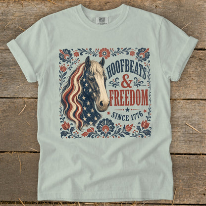Light blue t-shirt with patriotic horse and "Hoofbeats & Freedom Since 1776" text.