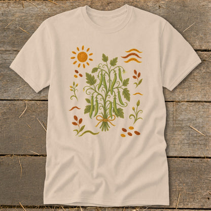 Cream t-shirt with a central bouquet of pea pods, sun, and floral elements.