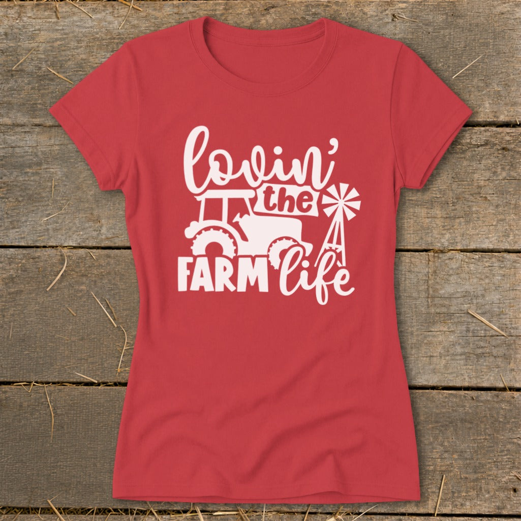 Red t-shirt with white text and graphic reading "lovin' the FARM life" with tractor and windmill.