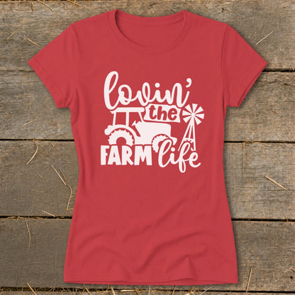 Red t-shirt with white text and graphic reading "lovin' the FARM life" with tractor and windmill.