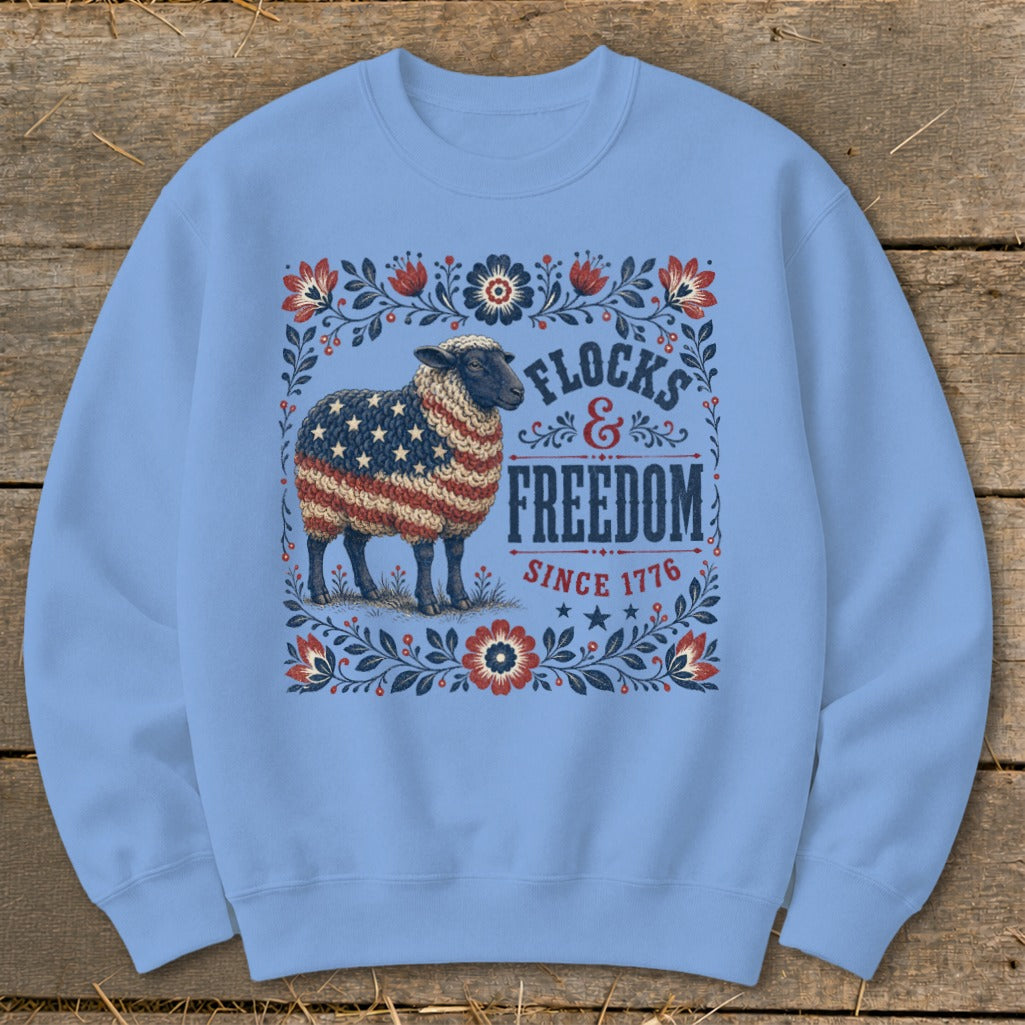 Light blue sweatshirt with a patriotic sheep design and "Flocks & Freedom Since 1776" text.