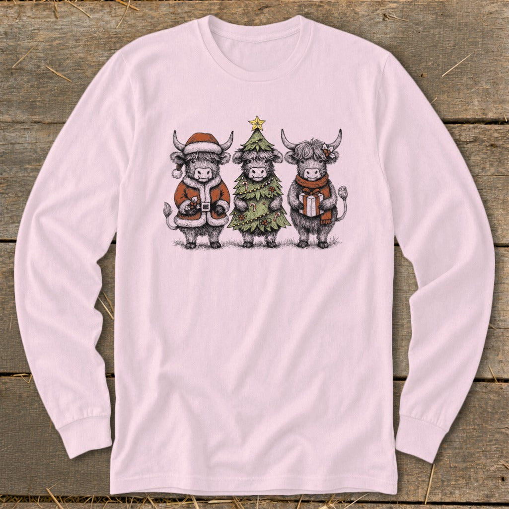 Three highland cows dressed for Christmas: one in a Santa suit, one as a tree, one with a gift.