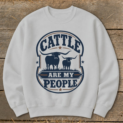 White sweatshirt with "Cattle Are My People" text and longhorn bull graphic.