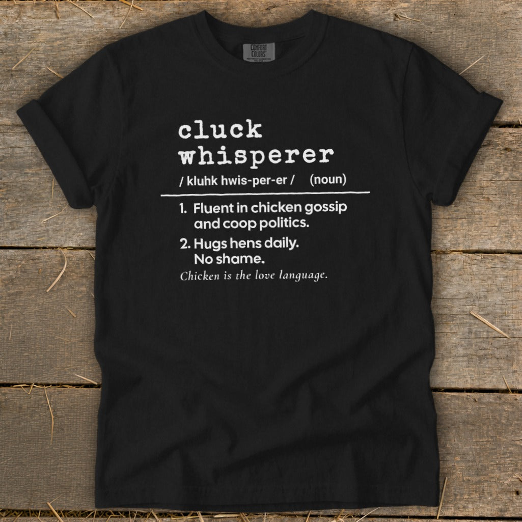 Black t-shirt with "Cluck Whisperer" definition: fluent in chicken gossip, hugs hens daily, no shame.