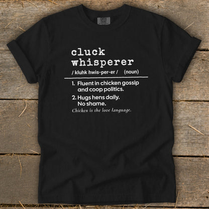Black t-shirt with "Cluck Whisperer" definition: fluent in chicken gossip, hugs hens daily, no shame.