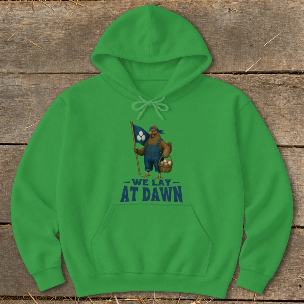 Green hoodie with chicken holding flag and basket of eggs, text "We lay at dawn".
