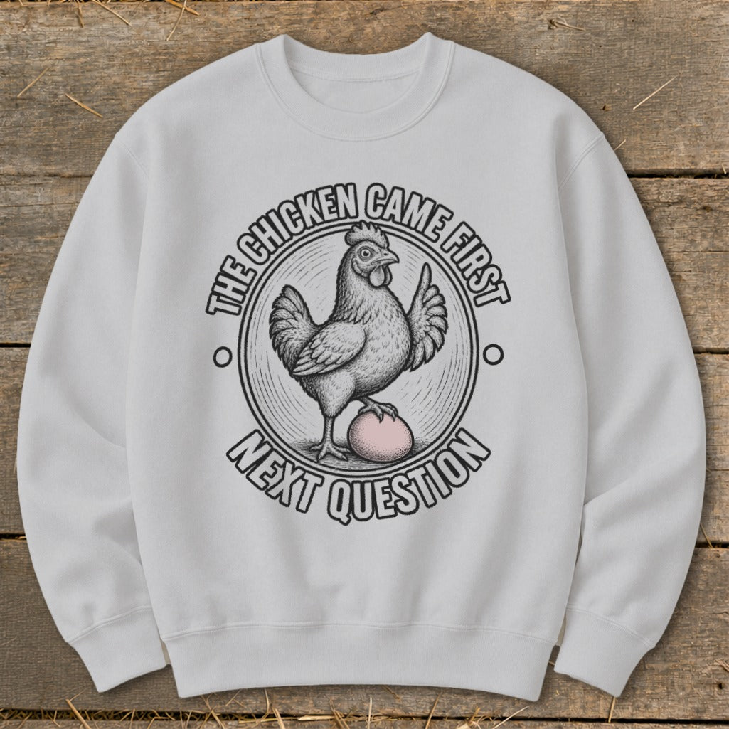 White sweatshirt with a graphic of a chicken and egg, "The Chicken Came First Next Question".