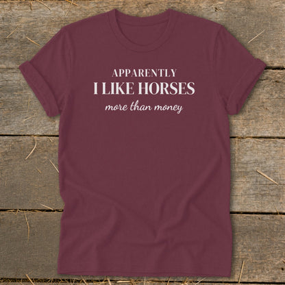 Maroon t-shirt with white text "APPARENTLY I LIKE HORSES more than money".