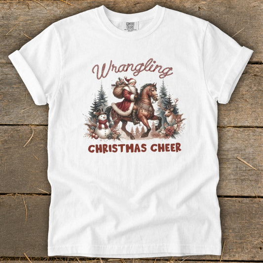 White t-shirt with "Wrangling Christmas Cheer" graphic featuring Santa on horseback.