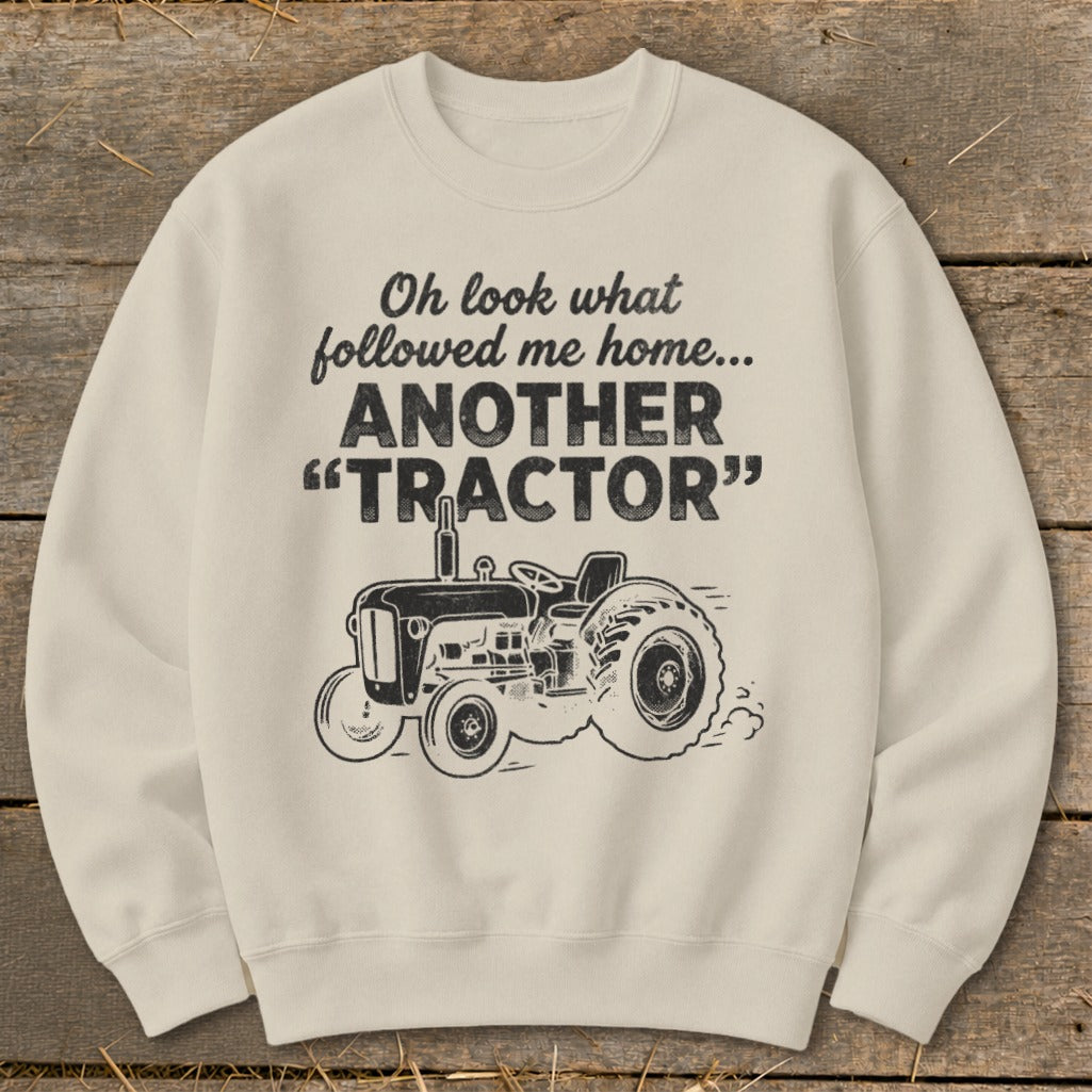 Cream sweatshirt with text "Oh look what followed me home... ANOTHER TRACTOR" and tractor graphic.
