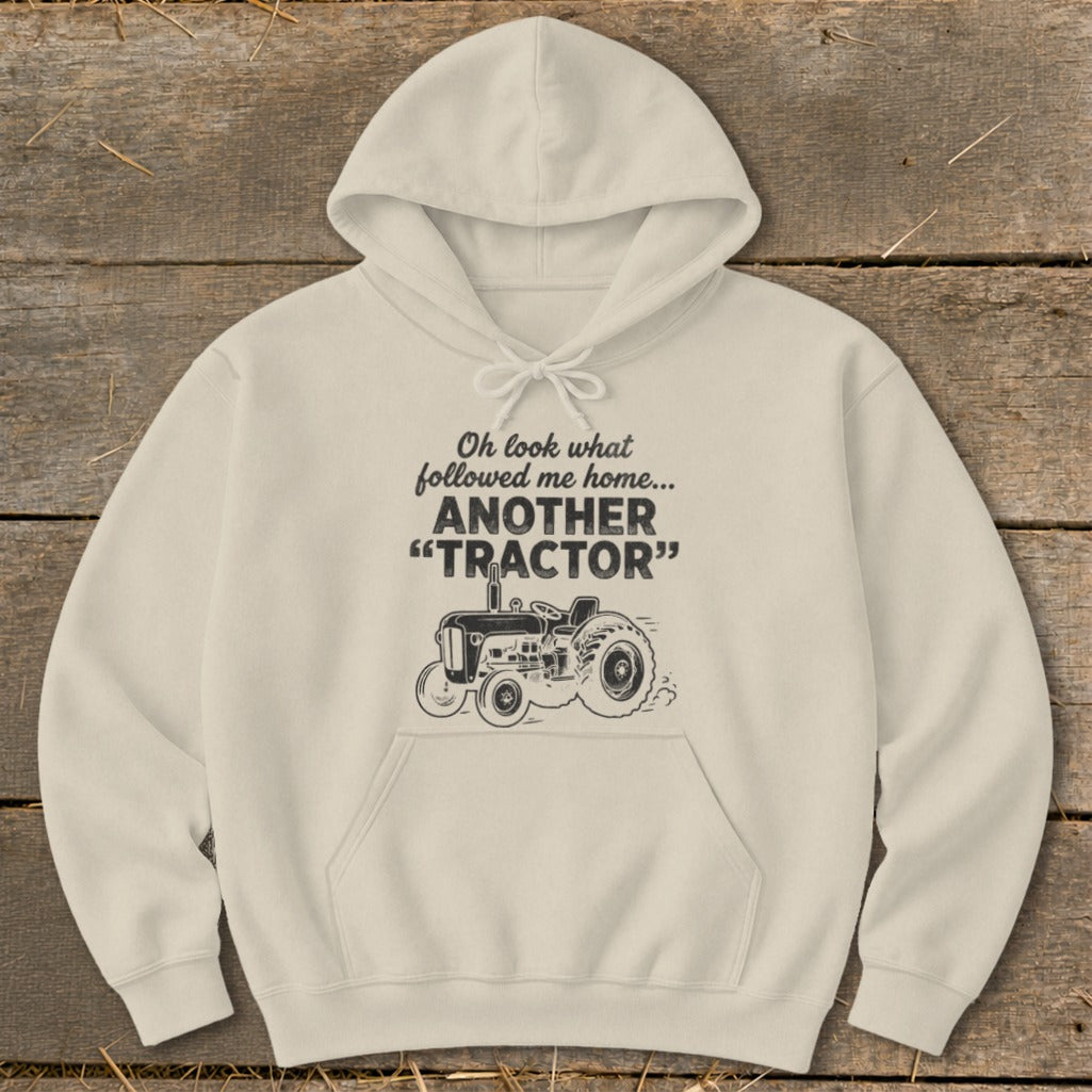 Light cream hoodie with "Oh look what followed me home... ANOTHER 'TRACTOR'" text and tractor graphic.