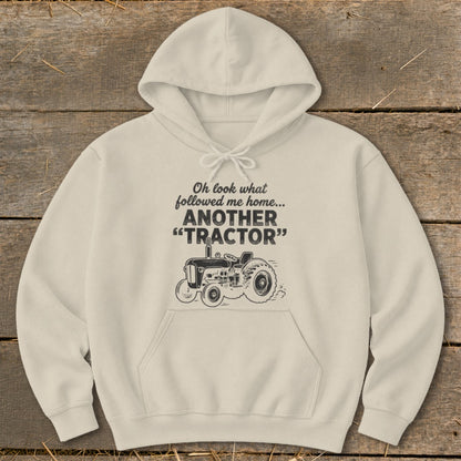 Light cream hoodie with "Oh look what followed me home... ANOTHER 'TRACTOR'" text and tractor graphic.