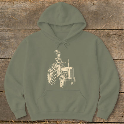 Olive green hoodie with a graphic of a woman in vintage clothing driving a tractor.