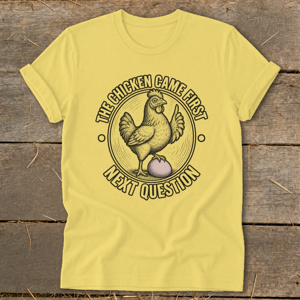 Yellow t-shirt with a chicken on an egg and text "The chicken came first, next question".