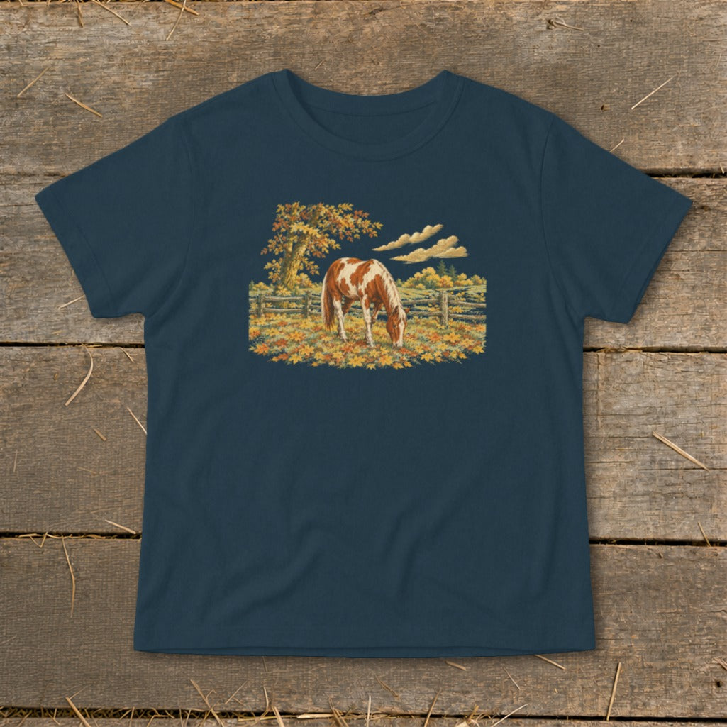 Navy t-shirt with a pinto horse grazing in a meadow with autumn leaves.