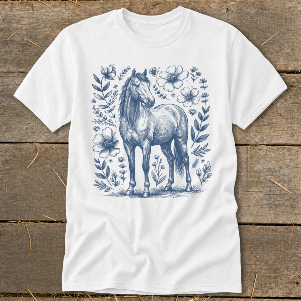 White t-shirt with a blue sketch of a horse surrounded by flowers and leaves.