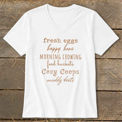 White v-neck shirt with "fresh eggs happy hens MORNING CROWING feed buckets Cozy Coops muddy boots" text.