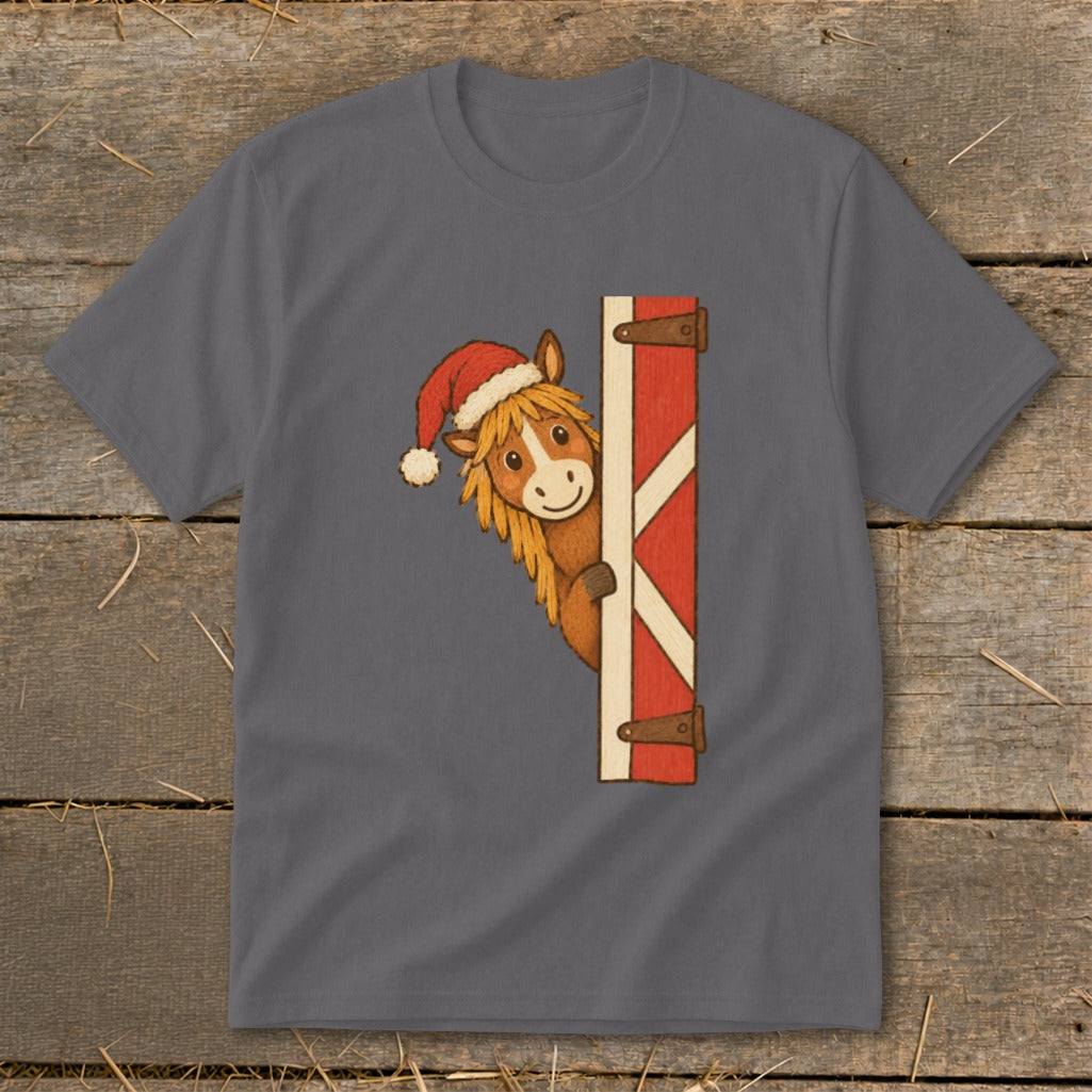Horse wearing Santa hat peeking around a barn door graphic on a t-shirt.