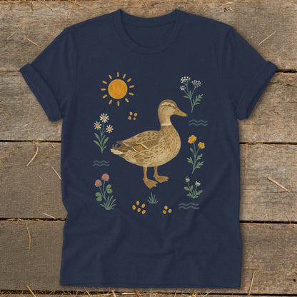 Navy t-shirt with a watercolor illustration of a duck surrounded by flowers and the sun.