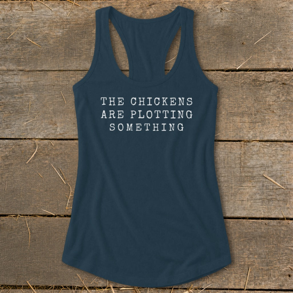 Navy blue racerback tank top with white text reading "THE CHICKENS ARE PLOTTING SOMETHING".