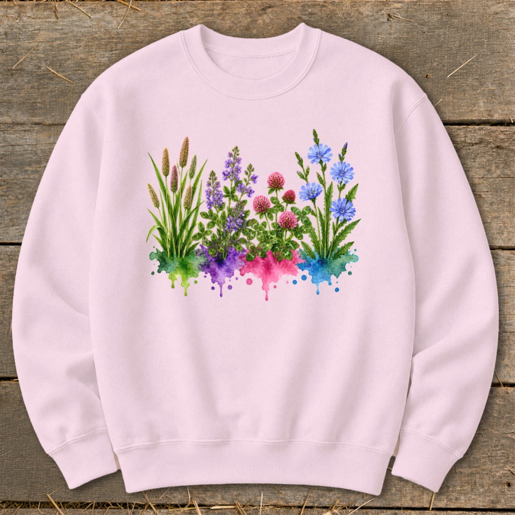 A light pink crewneck sweatshirt features a central graphic of watercolor wildflowers springing from colorful splatters.
