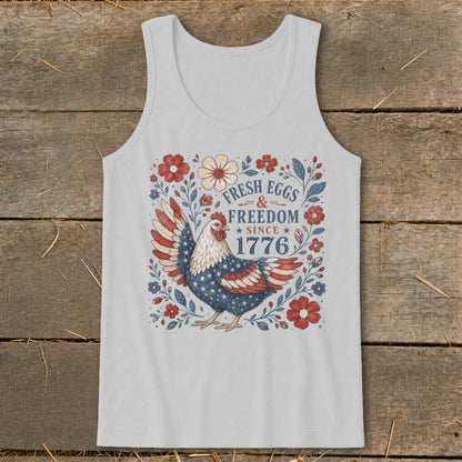 White tank top with patriotic chicken design and "Fresh Eggs & Freedom Since 1776" text.