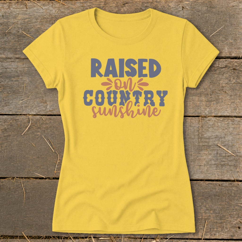 Yellow t-shirt with text "RAISED ON COUNTRY sunshine" in blue and pink.