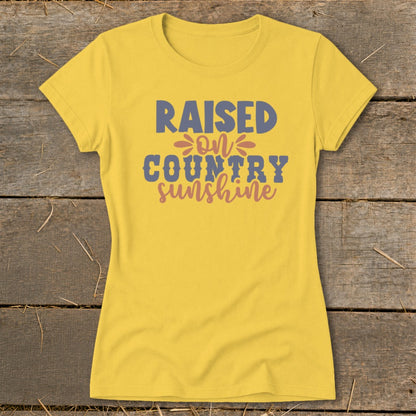 Yellow t-shirt with text "RAISED ON COUNTRY sunshine" in blue and pink.