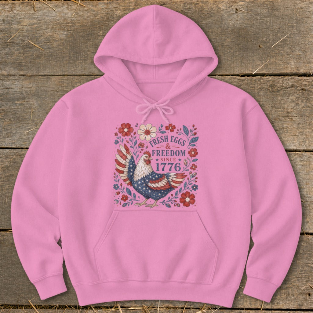 Pink hoodie with a graphic of a chicken and text "FRESH EGGS & FREEDOM SINCE 1776".