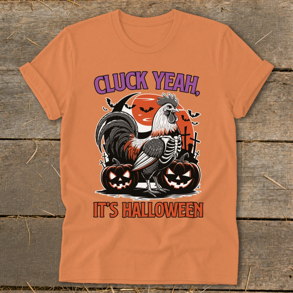 Orange t-shirt with skeleton rooster, pumpkins, bats, and text "CLUCK YEAH, IT'S HALLOWEEN."