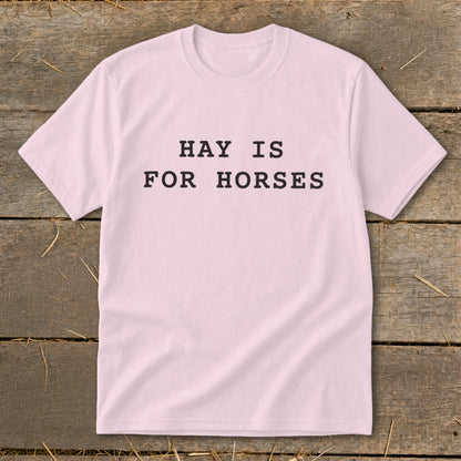 Pink t-shirt with black text that reads "HAY IS FOR HORSES".