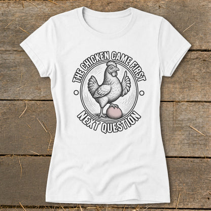 White t-shirt with graphic of chicken on egg, text reads "The chicken came first, next question".