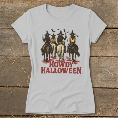Four witches on horseback ride forward with brooms and bats, text reads "HOWDY HALLOWEEN".