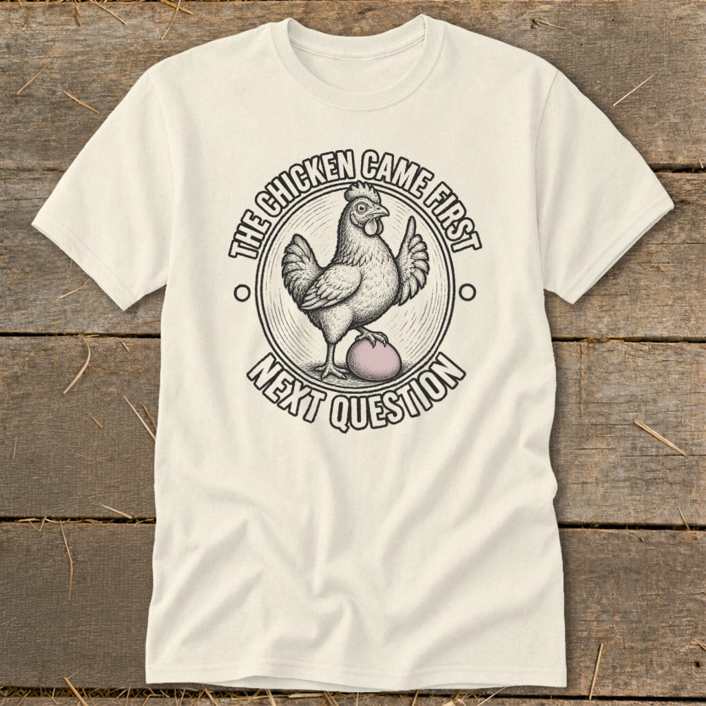 Cream t-shirt with a chicken and egg design saying "The chicken came first, next question".