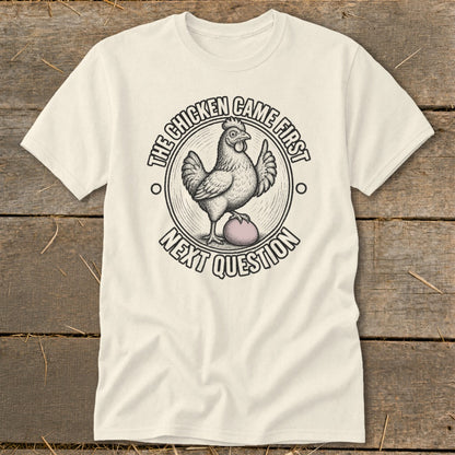 Cream t-shirt with a chicken and egg design saying "The chicken came first, next question".
