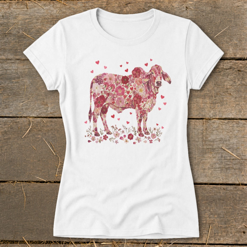 White t-shirt with a pink floral cow graphic and small hearts.