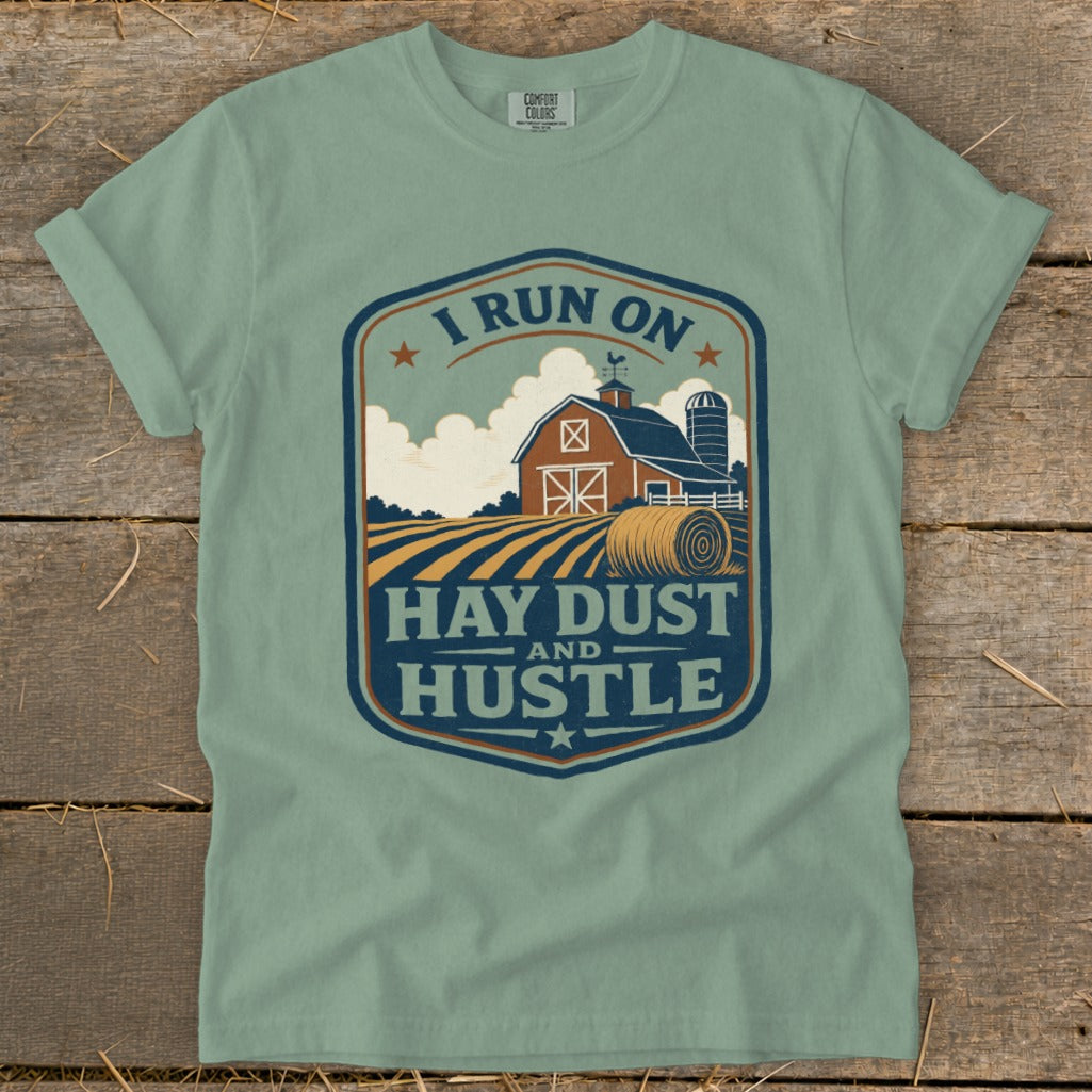 Green t-shirt with barn, silo, hay bales, and text "I Run On Hay Dust And Hustle".