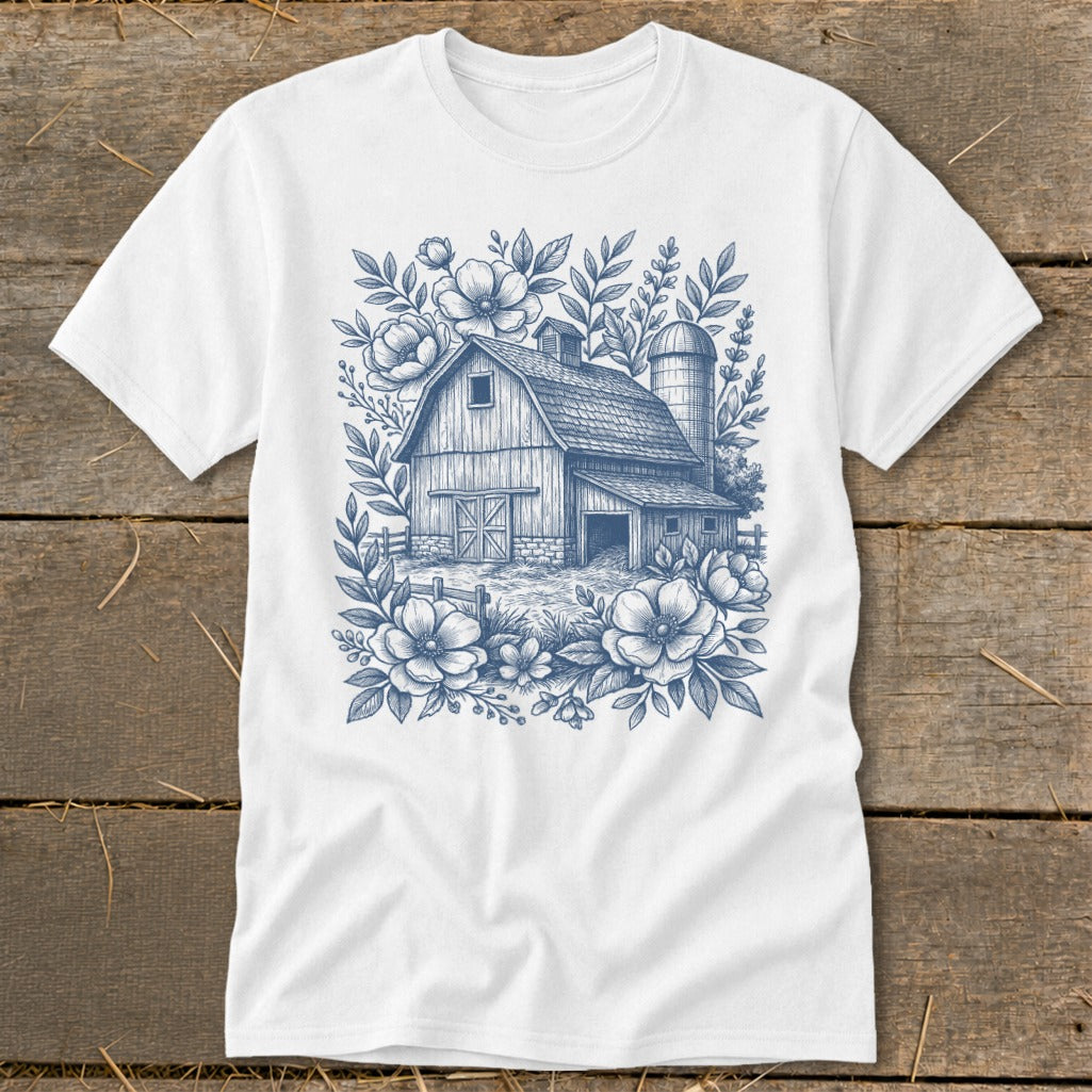 White t-shirt with a blue barn and floral sketch design.