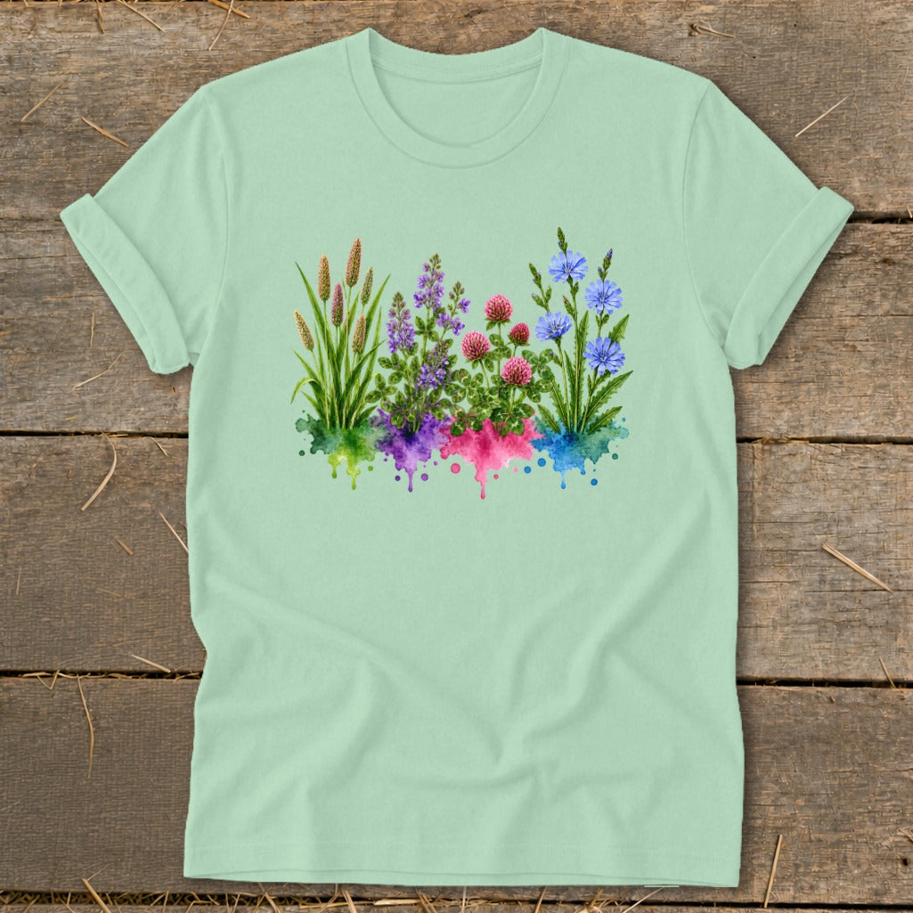 A light green t-shirt with a graphic of colorful watercolor wildflowers printed on the center.