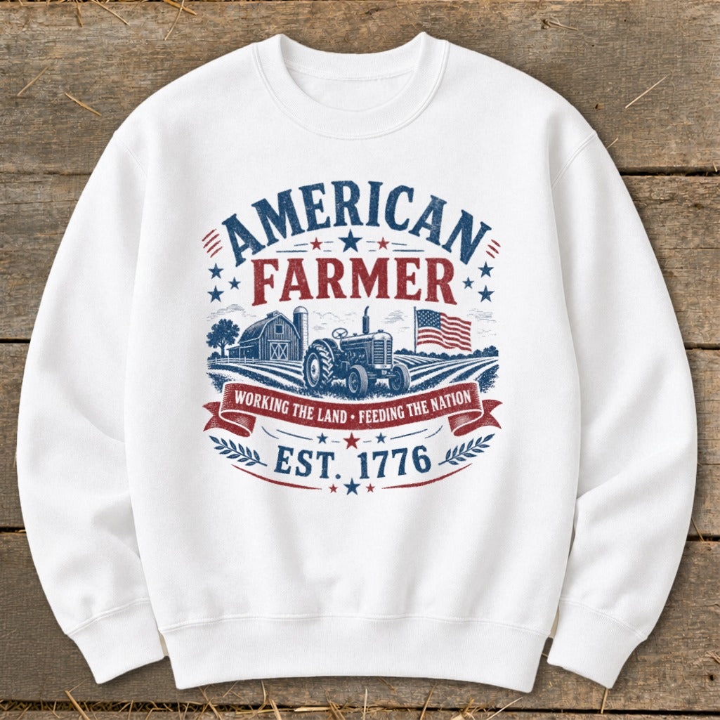 White sweatshirt with "American Farmer" graphic, tractor, barn, and flag.