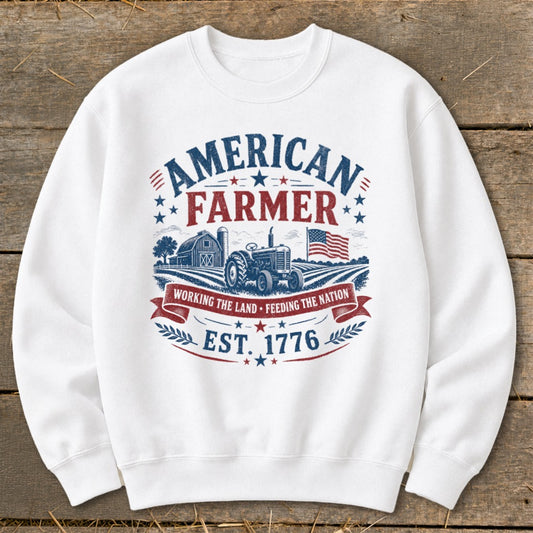 White sweatshirt with "American Farmer" graphic, tractor, barn, and flag.